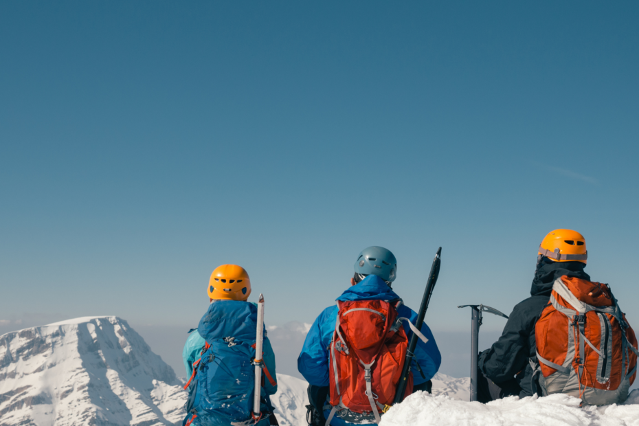 3 climbers looking at mountain peaks